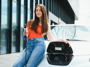 Femeie așteptând mașina electrică la încărcat - Foto: Freepik