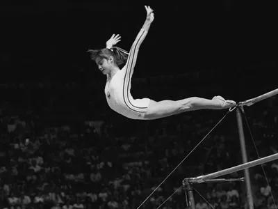 În această fotografie de arhivă din 18 iulie 1976, Nadia Comăneci, din România, coboară de la paralele inegale în timpul unei performanțe perfecte de "10" la Jocurile Olimpice de vară de la Montreal, Canada Foto: profimediaimages.ro