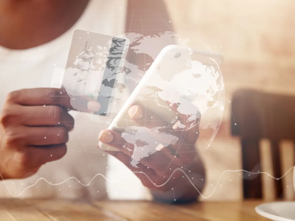 Femeie cu card de credit şi smartphone, văzută printr-un display transparent cu globul planetar - Foto: Magnific.com/wayhomestudio