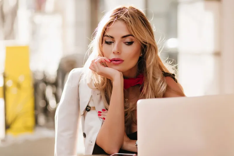 T&acirc;nără femeie de afaceri lucr&acirc;nd la computer, &icirc;ntr-o cafenea - Foto: Magnific.com/lookstudio