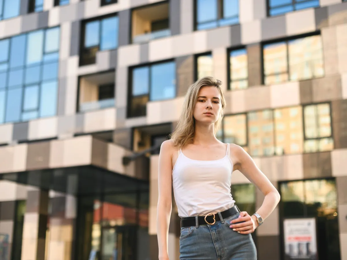 Femeie în fața unui bloc - Foto: Freepik