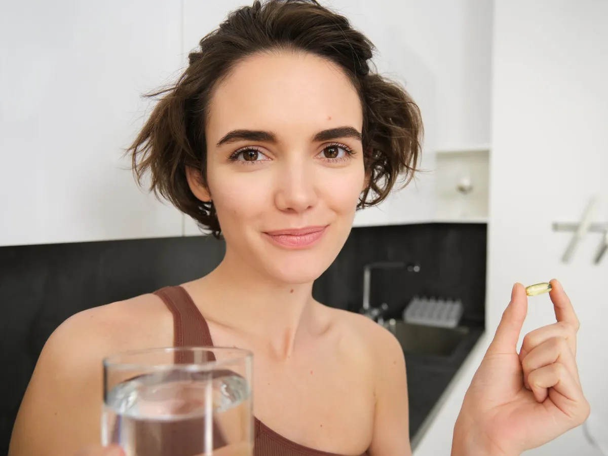 Femeie care are o pastilă în mână - Foto: Freepik (rol ilustrativ)