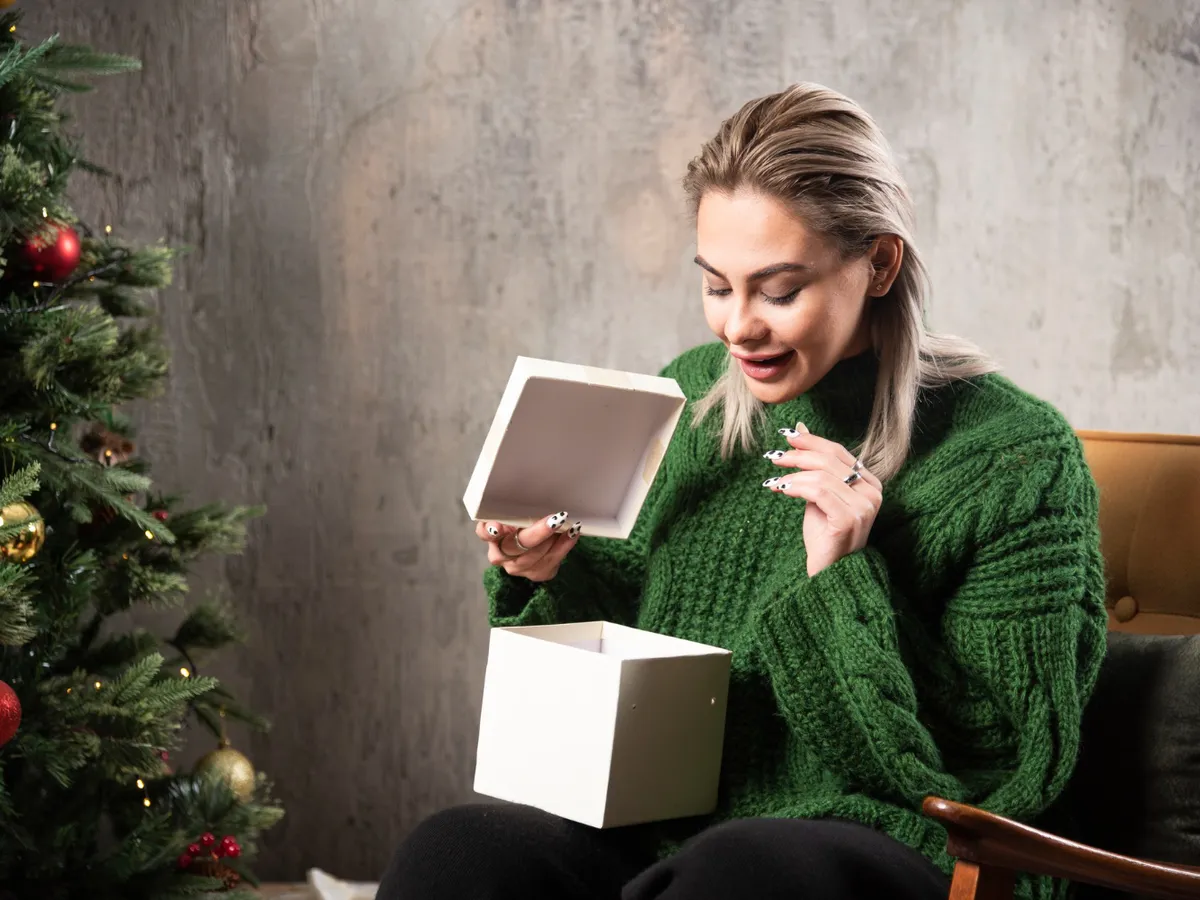 Femeie care deschide un cadou - Foto:  Freepik  (Imagine cu rol ilustrativ)