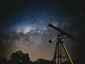 Telescop negru, pe fundalul unui cer albastru-alburiu, noaptea - Foto: Pexels/Lucas Pezeta