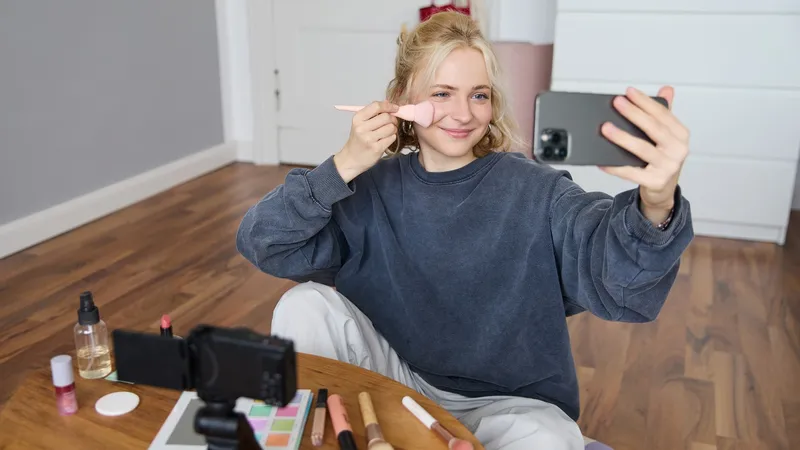 Tânără influencer transmițând în direct o ședință de machiaj - Foto: Freepik (cu rol ilustrativ)