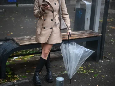 Domnişoară citind ştirile pe telefon, între două reprize de ploaie - Foto: INQUAM PHOTOS/Alex Nicodim
