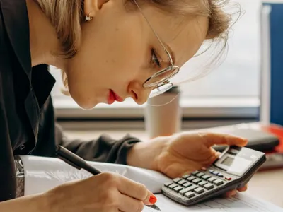 Femeie adâncită în calcule complicate - Foto: Pexels/Mikhail Nilov