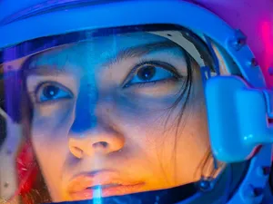 Femeie în combinezon de cosmonaut uitându-se la stele - Foto: Pexels/Mikhail Nilov