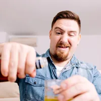 Bărbat care toarnă alcool într-un pahar - Foto: Freepik (imagine cu rol ilustrativ)