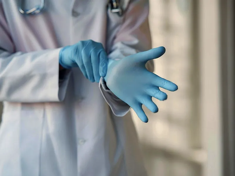 Cadru medical punându-şi mănuşi de protecţie - Foto: Pexels/Gustavo Fring