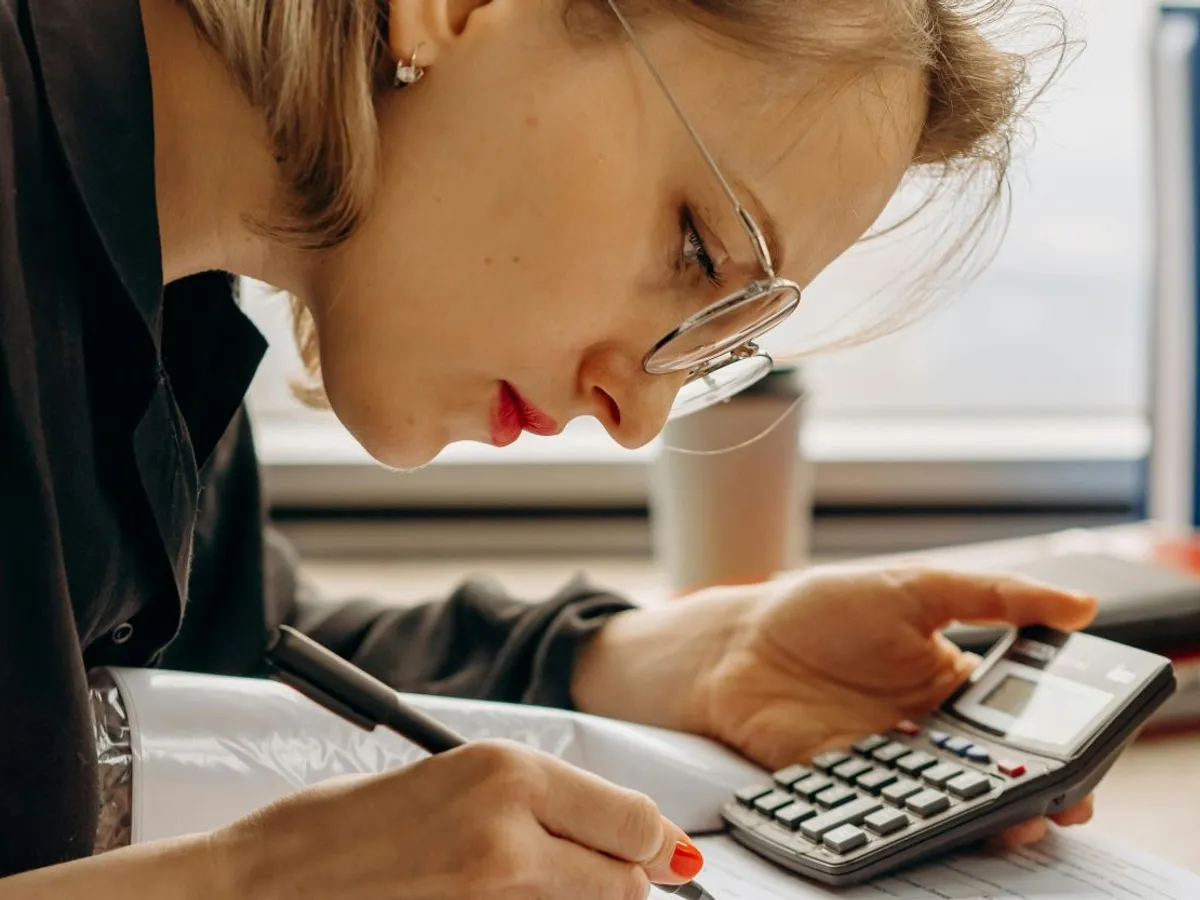 Femeie concentrată, făcând calcule complicate - Foto: Pexels/Mikhail Nilov