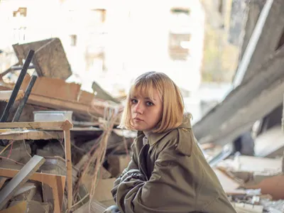 O femeie stă lângă o casă devastată de războiul din Ucraina - Foto: Magnific.com/pvproductions