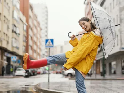 Femeie cu umbrelă stând în ploaie - Foto: Freepik/CC0