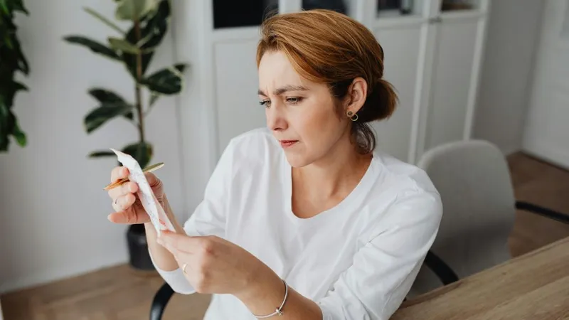 Femeie la birou, uitându-se la fluturaşul de salariu - Foto: Pexels/Kaboompics.com