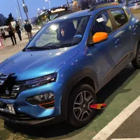 Mașină electrică pusă la încărcat la o stație publică, cu roata blocată de primărie. - Foto: Facebook/Valentin Burghiu