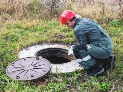 Bărbat lângă o gură de canal - Foto: Magnific.com (Imagine cu rol ilustrativ)