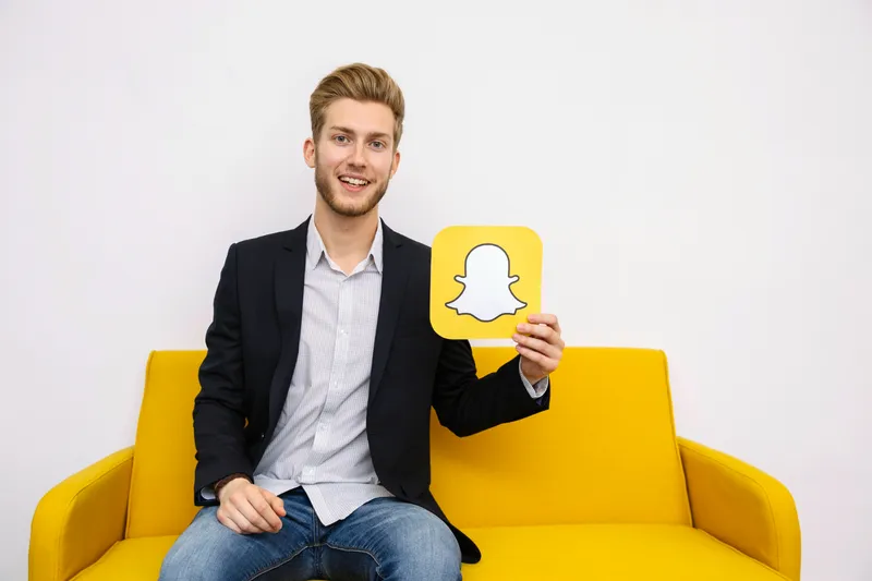 Bărbat care ține o poză cu aplicația Snapchat - Foto: Freepik (rol ilustrativ)