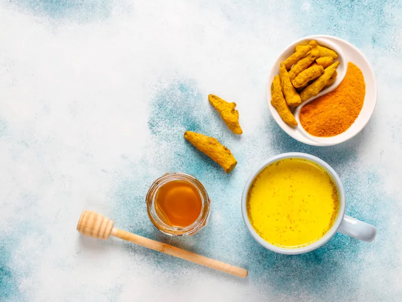 Turmeric și miere așezate pe o suprafață - Foto: Freepik