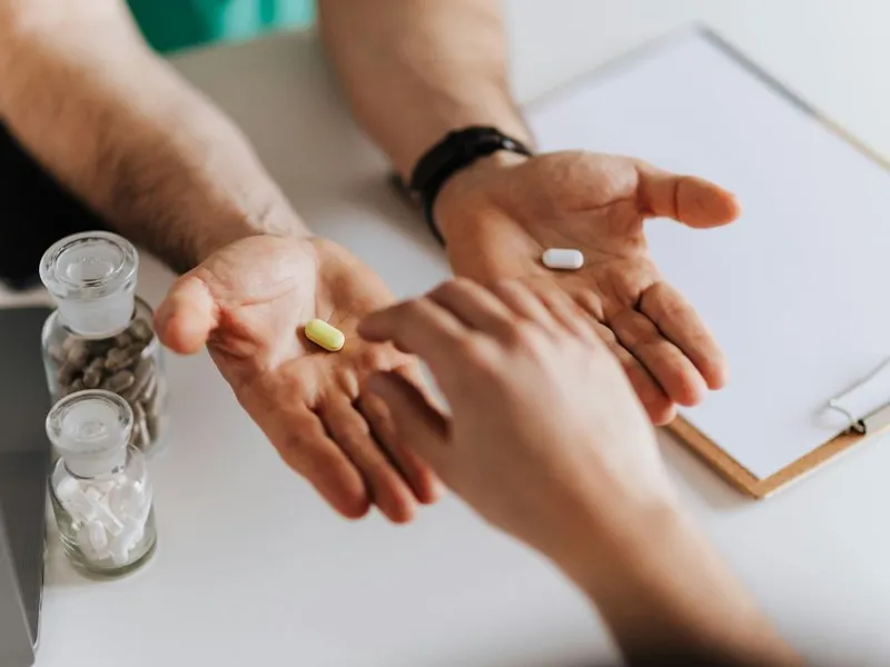 Doctor oferindu-i unui pacient alegerea pastilei potrivite - Foto: Pexels/Karolina Grabowska