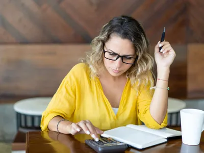 Femeie concentrată făcând calcule complicate - Foto: Freepik/katemangostar