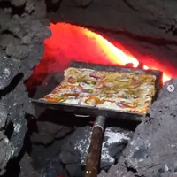 Fluxul de lavă incandescentă se mişcă lent, iar căldura rocilor găteşte ''Pizza Pacaya'', denumită astfel după vulcanul din sudul statului Guatemala. / Foto: agerpres.ro