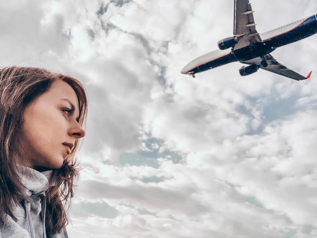 Femeie frumoasă care are deasupra capului un avion - Foto: Freepik (imagine cu rol ilustrativ)