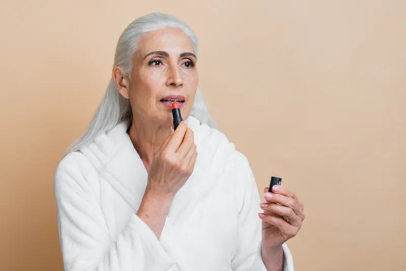 Femeie care dă cu ruj - Foto: Magnific.com (Imagine cu rol ilustrativ)