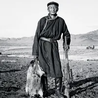Un vânător cu o marmotă abia prinsă. Veverițele de dimensiuni mari sunt o delicatesă la mare preț în Mongolia