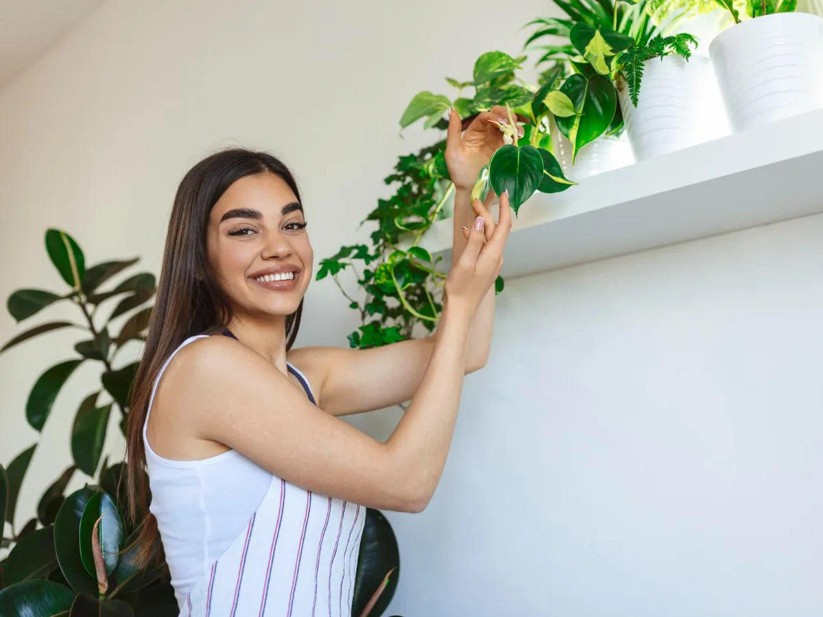 Femeie care ține o plantă - Foto: Freepik (Imagine cu rol ilustrativ)