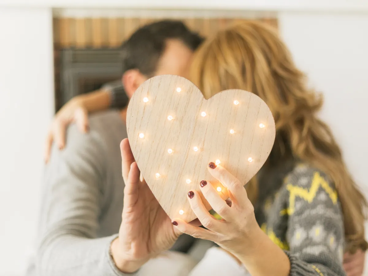 Cuplu adult sărutându-se și acoperindu-se cu o inimă - Foto: Magnific.com (Imagine cu rol ilustrativ)