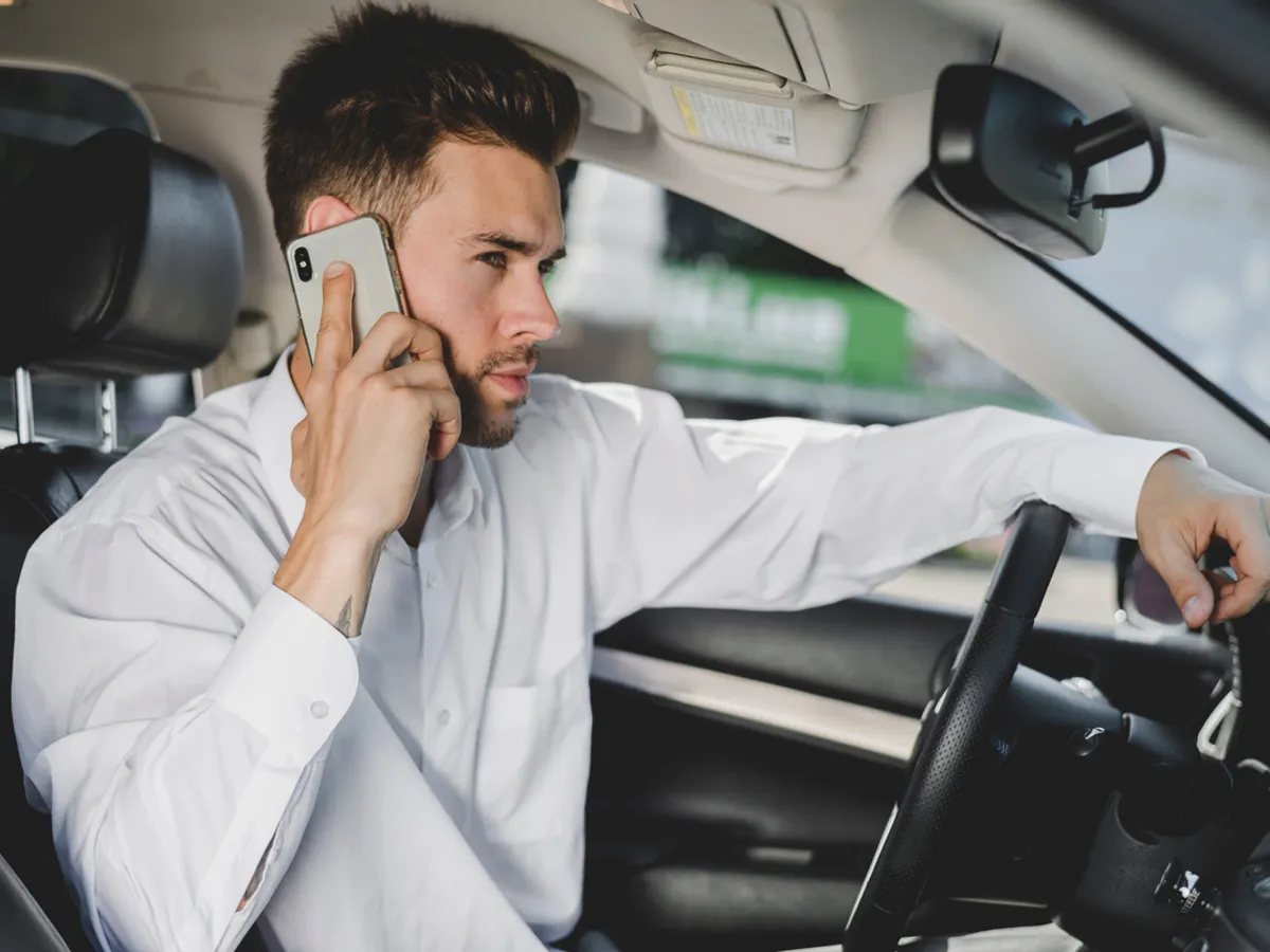 Un șofer vorbește la telefon fără handsfree - Foto: magnific.com (Imagine cu rol ilustrativ)