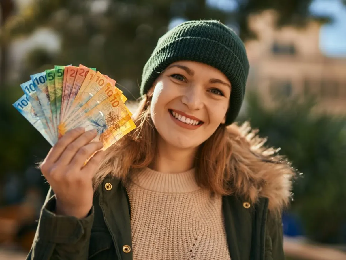 Fată cu un evantai de bancnote euro - Foto: Freepik/krakenimages.com