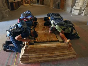 Şase pelerini, la Piatra de ungere, unde se presupune că a fost depus Iisus, după coborîrea de pe Cruce - Foto: Profimedia Images