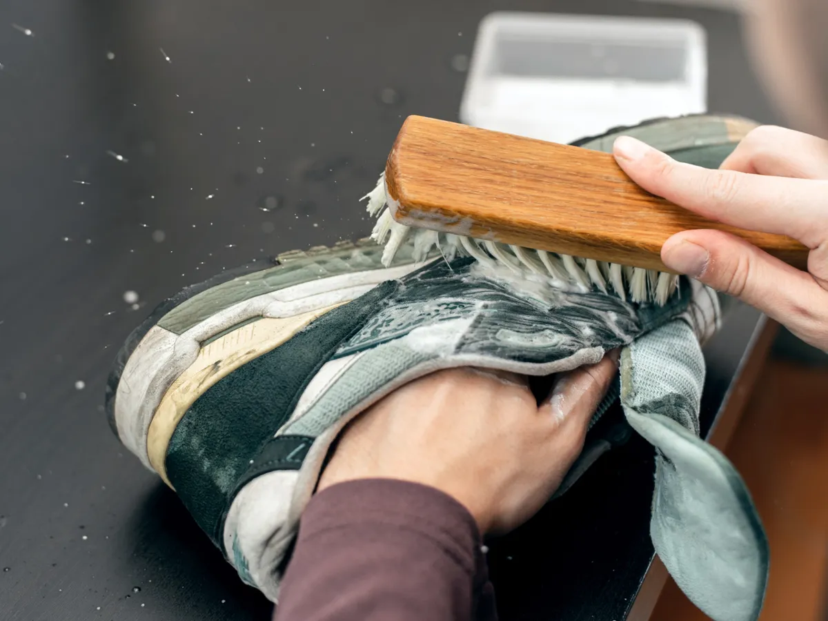 Persoană care curăță pantofii - Foto: Freepik (Imagine cu rol ilustrativ)