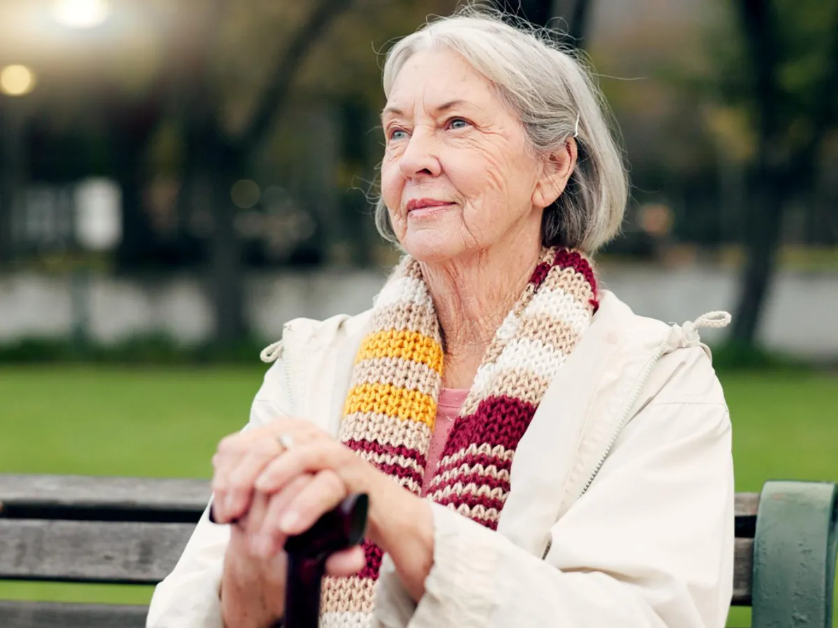 Pensionară pe o bancă în parc - Foto: Freepik