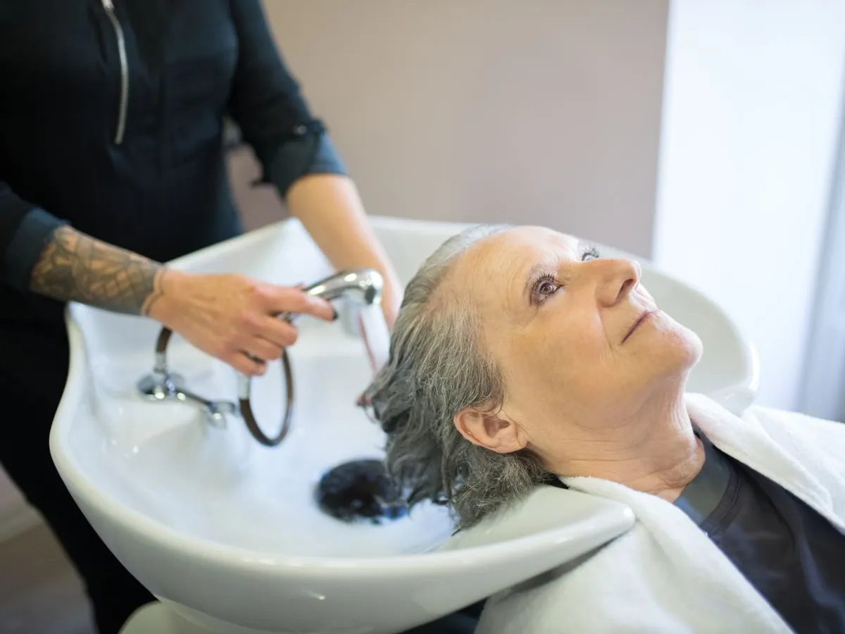 Femeia în vârstă își spală părul de către un stilist într-un salon  - Foto: Pexels (Imagine cu rol ilustrativ)