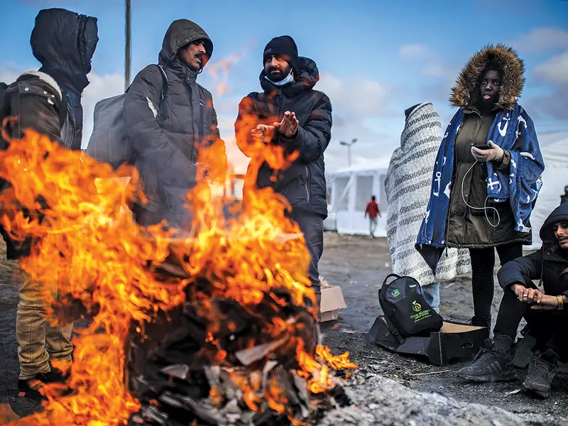 Le ia refugiaților două-trei zile la temperaturi sub zero grade pentru a ajunge în Polonia (aici, oameni care se încălzesc la trecerea Medika)