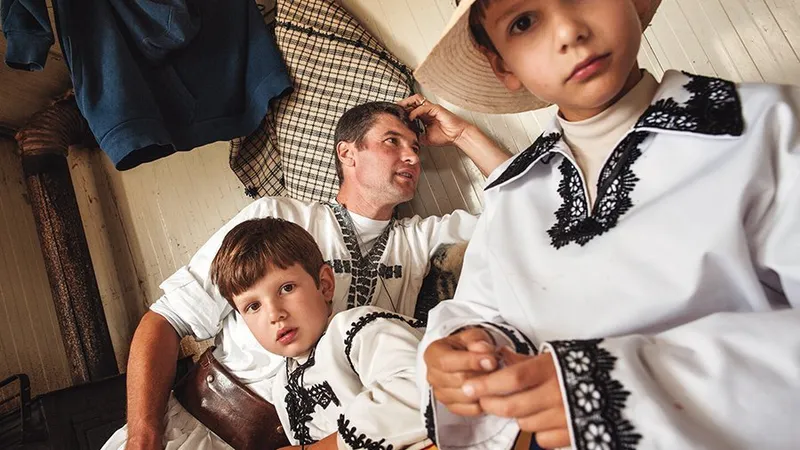 Tată cu cei doi băieți în coliba stânei familiei din munții Trăscăului