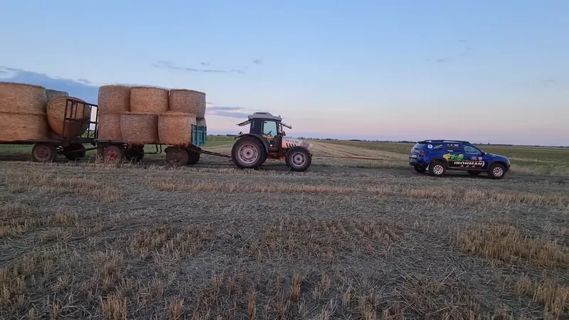 Dacia Duster trage 2 tractoare și 4 remorci cocoșate de baloți de paie. Total: 30 tone. / Foto: captură video