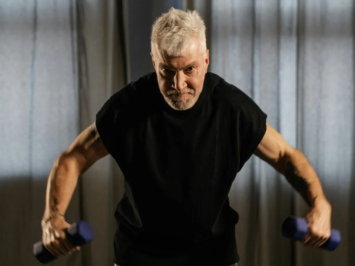 Bărbat în etate ridicând gantere - Foto: Pexels/Alena Darmel