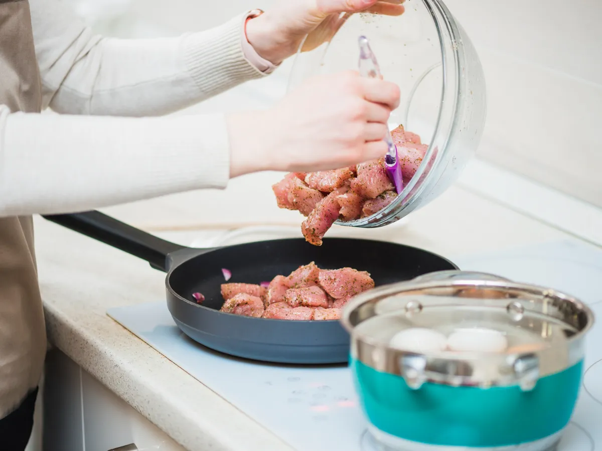 Persoană care gătește carne - Foto: Freepik (Imagine cu rol ilustrativ)