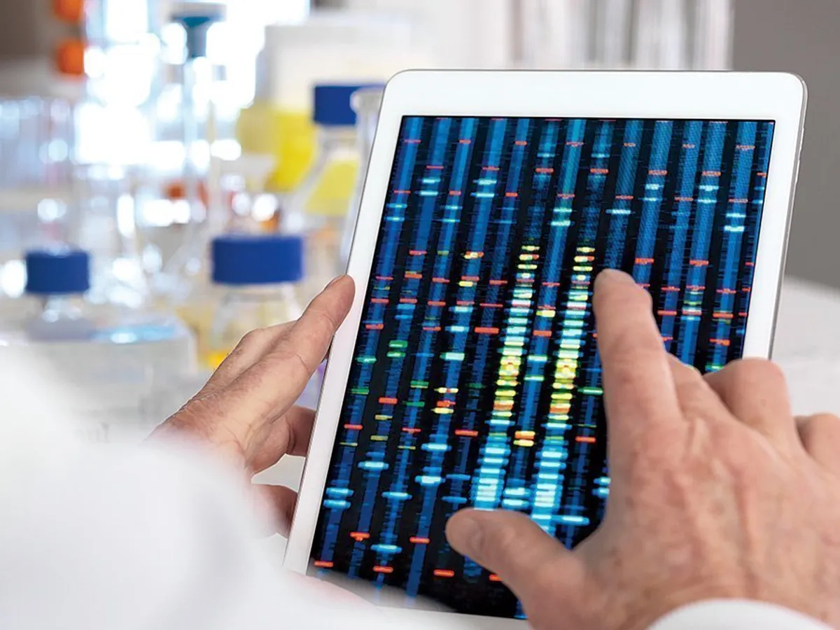Un om de știință vizualizează rezultatele unui test genetic pe o tabletă digitală