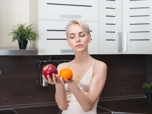 Femeie frumoasă care ține în mână fructe - Foto: Freepik