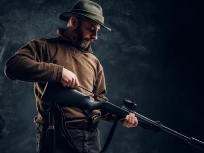 Un bărbat își pregătește arma pentru vânătoare - Foto: Freepik (rol ilustrativ)