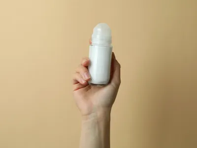 Mână feminină ține deodorant gol pe fundal - Foto: Magnific.com (Imagine cu rol ilustrativ)