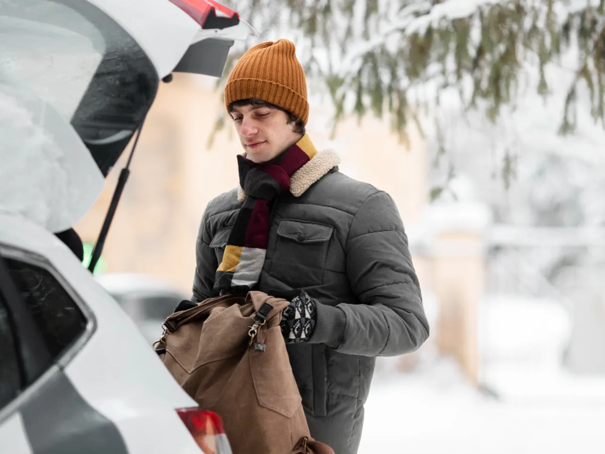 Bîrbat îmbrăcat gros lângă mașină - Foto: Freepik (rol ilustrativ)