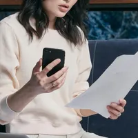 Femeie făcând calcule, cu telefonul în mână - Foto: Pexels/Mikhail Nilov