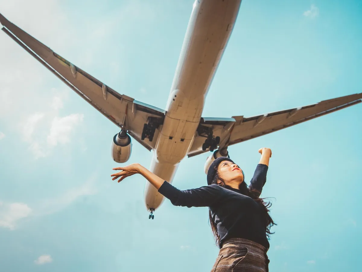 Femeie care are deasupra ei un avion - Foto: Freepik (imagine cu rol ilustrativ)