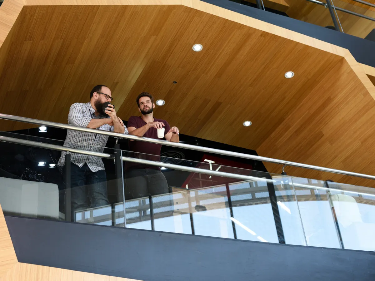 Doi bărbați care stau la balconul unui bloc - Foto: Freepik (rol ilustrativ)