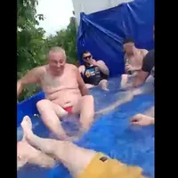 Mai mulți bărbați au întins o prelată în bena unui camion, au umplut-o cu apă și s-au plimbat cu „piscina mobilă” pe străzi. / Foto: captură video